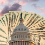 US flag flies in front of the US Capitol in Washington DC with cash behind the dome to illustrate coronavirus stimulus payment