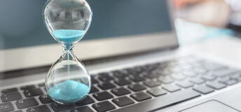 Hourglass on laptop computer concept for time management and countdown to deadline