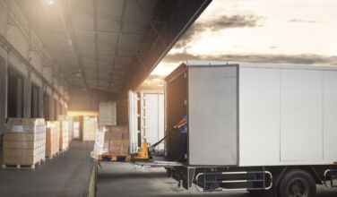 Photo of a semi-trailer truck that is ready to be loaded at a warehouse.