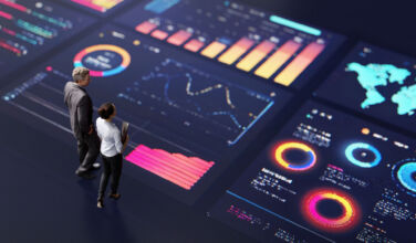 Pluto’s £2bn bet with Blackstone affirms pan-European expansion Abstract people standing on a large digital screen, analysing interactive data visualisations and charts for strategic planning. Representing teamwork, technology, and data-driven decision making in a corporate environment.