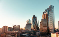 Wide angle of sun setting over London Gherkin.
