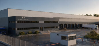 A photo of a large industrial building and it's accompanying car park