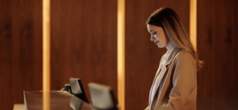 Loans in focus: Aareal issues โฌ406m loan for European hotels, Grainger receives ยฃ540m refinancing, Vรคrde issues โฌ275m in Germany Woman working at a hotel reception desk